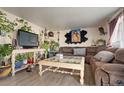 Cozy living room with plush sectional sofa and an eclectic collection of houseplants at 3023 S Fenton St, Denver, CO 80227