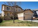 Charming two-story home with a manicured lawn, stone accents, and an attached two-car garage at 6370 Twilight Ave, Firestone, CO 80504