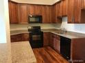 Efficient kitchen featuring granite counters, wooden cabinets, and black appliances at 804 Summer Hawk Dr # 6105, Longmont, CO 80504