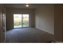 Neutral living room with natural light from sliding glass door, offering outdoor views at 804 Summer Hawk Dr # 6105, Longmont, CO 80504
