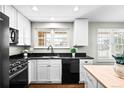 Well-lit kitchen with white cabinetry, black countertops, and stainless steel appliances at 1765 S Endicott St, Lakewood, CO 80232