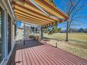 Inviting back deck with a striped awning, offering outdoor living space and views of the green area at 2446 S Vaughn Way # A, Aurora, CO 80014