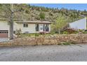 Ranch home featuring a landscaped yard and a retaining wall at 4 Virginia St, Idaho Springs, CO 80452