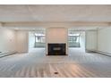 Open floor plan features a fireplace and windows offering a view of the outdoors at 7000 E Quincy Ave # 317, Denver, CO 80237