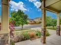 Inviting front porch with stone columns and manicured landscaping with an open view of the street at 11649 E 111Th Ave, Commerce City, CO 80640