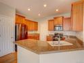 Spacious kitchen featuring a granite island with sink, stainless steel appliances, and ample cabinet space at 11649 E 111Th Ave, Commerce City, CO 80640