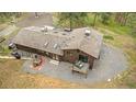 Aerial view of a brown home with a stone chimney, multiple skylights, and a backyard deck at 2013 Swede Gulch Rd, Evergreen, CO 80439