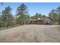 Wide gravel driveway leading up to a house nestled in a pine forest at 2013 Swede Gulch Rd, Evergreen, CO 80439