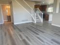 Bright and airy living room featuring luxury vinyl plank flooring and an open staircase to the second floor at 9768 Mayfair St # E, Englewood, CO 80112