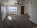 A bright living room featuring neutral walls and plush carpet with ample natural light from large windows at 698 S 2Nd Ave, Brighton, CO 80601