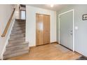 Bright entryway with staircase, coat closet, and light wood floors at 1490 S Iris St, Lakewood, CO 80232