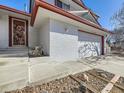 House exterior showing front entrance and attached garage at 1490 S Iris St, Lakewood, CO 80232