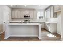 Spacious kitchen features white cabinets, quartz countertops, stainless steel appliances, and wood floors at 2283 Serenidad St, Brighton, CO 80601