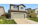 View of the home's exterior, with a two-car garage, green lawn, and some landscaping at 5327 Suffolk Cir, Castle Rock, CO 80104