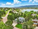Charming two-story home with well-manicured lawn, mature trees, and a view of mountains and lake at 18590 Lower Lake Rd, Monument, CO 80132