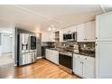 Modern kitchen features stainless steel appliances, white cabinetry, updated backsplash, and sleek countertops at 2885 E Midway Blvd # 1542, Denver, CO 80234