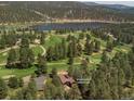 Breathtaking aerial view of the home near a golf course and a pristine lake surrounded by trees at 29090 Golf Way, Evergreen, CO 80439