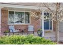 Inviting front porch with brick accents, seating area, and a beautifully decorated front door at 6708 S Niagara Ct, Centennial, CO 80112