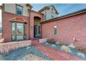 Charming brick home exterior featuring a walkway leading to the front door, with a bay window at 8727 Hunters Hill Ln, Littleton, CO 80125
