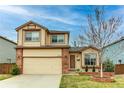 Two-story home with tan siding, brick accents, and a well-maintained front yard at 10652 Hyacinth St, Highlands Ranch, CO 80129