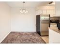 Bright dining area with carpet and view into kitchen at 7695 E Quincy Ave # 207, Denver, CO 80237