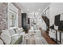 Open-concept living room features exposed brick, modern kitchen, and staircase access at 1024 W 8Th Ave, Denver, CO 80204