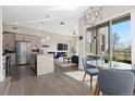 Open floor plan with modern kitchen, living room with fireplace, and adjacent dining area with natural light at 5026 S Platte River Pkwy, Littleton, CO 80123