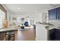 Bright and airy living room featuring wood floors, fresh white walls, and seamless kitchen access at 3047 W 47Th Ave # 607, Denver, CO 80211