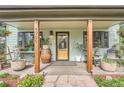 Inviting covered front porch with wooden columns, stylish decor, and a charming entryway at 4965 Dover St, Arvada, CO 80002