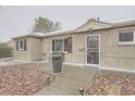 Close-up of a brick home featuring a decorative storm door and a well-kept rock garden at 9391 Lilly Ct, Thornton, CO 80229