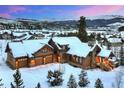 Stunning snow-covered home with a three-car garage and scenic mountain backdrop at 59 Gold Run Rd, Breckenridge, CO 80424