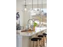 Kitchen island with seating, stainless steel appliances, and sleek pendant lighting at 10860 Lyric St, Lone Tree, CO 80134