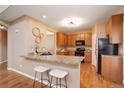 This kitchen features wooden cabinetry, granite countertops, a breakfast bar and stainless steel appliances at 10505 Wheeling St, Commerce City, CO 80022