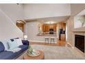 Bright, open concept showcasing a cozy living room with fireplace adjacent to the kitchen at 10505 Wheeling St, Commerce City, CO 80022