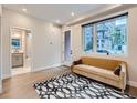 Sunlit living room features hardwood floors, stylish rug, comfortable sofa, and adjacent bathroom at 4025 Jason St # 101, Denver, CO 80211