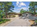 Charming home featuring a two-car garage and ample parking space with mature trees at 5073 N Lariat Dr, Castle Rock, CO 80108