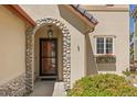 Charming front entrance with a stone archway and decorative window box under the window at 4194 Beautiful Cir, Castle Rock, CO 80109