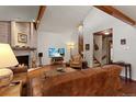 Bright living room featuring a fireplace, hardwood floors, comfortable leather seating, and a flat-screen TV at 16052 Deer Ridge Dr # B, Morrison, CO 80465