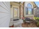 Close-up of front entry of a two-story home with a storm door and brick accents at 6868 Johnson St, Arvada, CO 80004