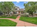 Charming two-story home featuring a quaint front porch, well-maintained lawn and beautiful landscaping at 5107 Pasadena Way, Broomfield, CO 80023