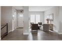 Bright living room features an open layout with hardwood floors, neutral walls, and comfortable seating at 8110 S Kellerman Cir, Aurora, CO 80016