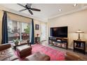 Cozy living room featuring hardwood floors, ceiling fan, and sliding glass doors to balcony at 48 Galapago St, Denver, CO 80223