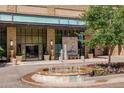 Beautiful entrance to The Landmark West, featuring a fountain, flowers, and manicured trees at 5455 Landmark Pl # 407, Greenwood Village, CO 80111