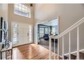 Bright foyer with hardwood floors, a grand staircase, and a view into the living room at 822 Shadowstone Dr, Highlands Ranch, CO 80129