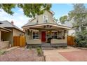 Inviting home exterior features a covered front porch, lush trees, and manicured landscaping at 3440 W 33Rd Ave, Denver, CO 80211