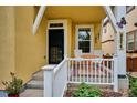 Inviting front porch with seating, a white railing, and a view of the landscaped yard at 9311 E 5Th Ave, Denver, CO 80230