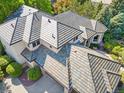 Aerial view of a house with a tile roof showcasing its unique pattern, with lush green trees surrounding the home at 5350 S Marshall St, Littleton, CO 80123