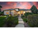 Beautifully landscaped home with a tiled roof, elegant entrance, and illuminated exterior for evening appeal at 5350 S Marshall St, Littleton, CO 80123