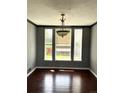 Bright dining room with hardwood floors and three large windows allowing ample sunlight at 5988 W Crestline Ave, Littleton, CO 80123