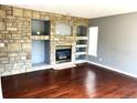 Cozy living room with a stone fireplace and built-in shelving at 5988 W Crestline Ave, Littleton, CO 80123